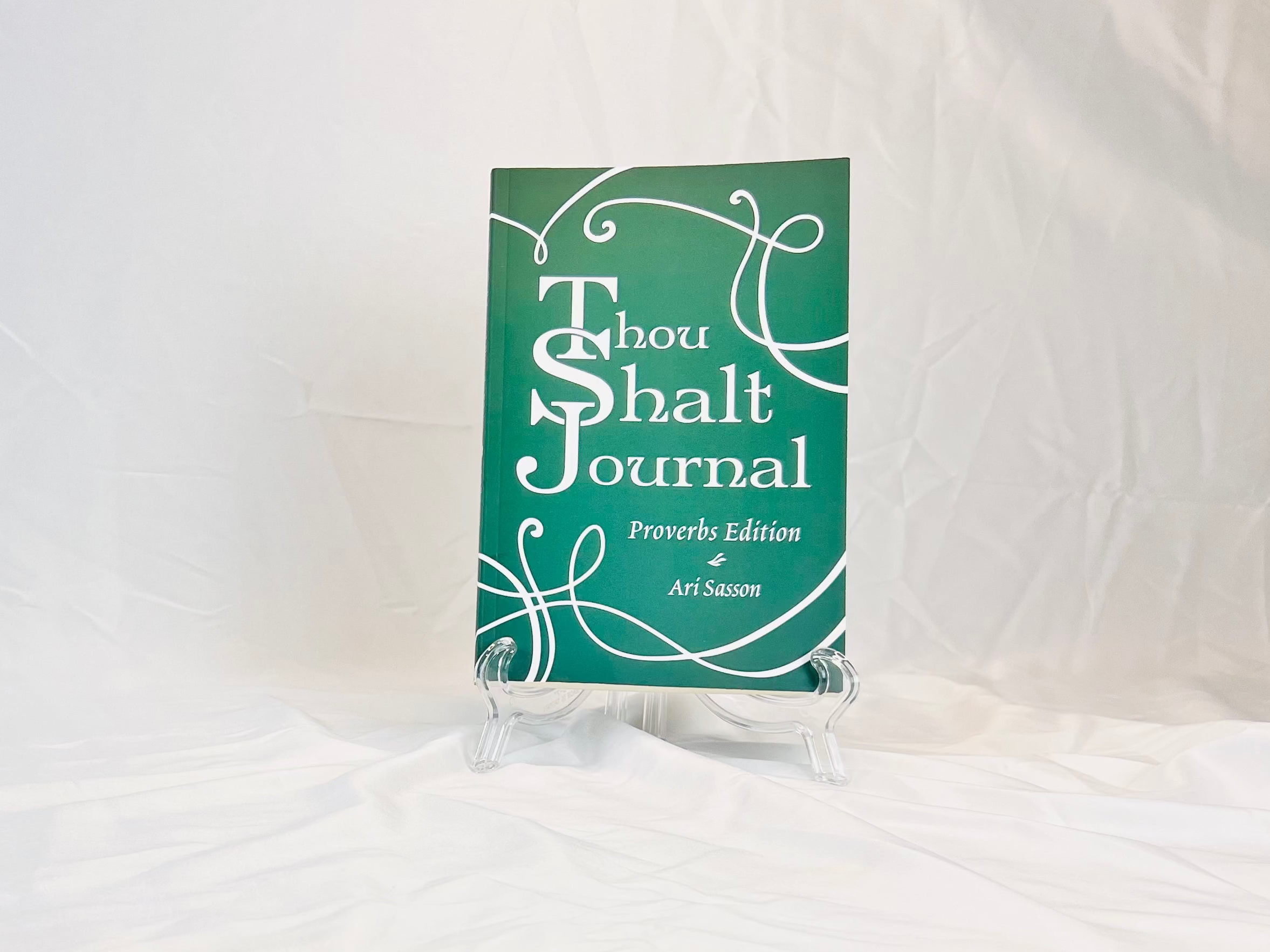 Green book titled 'Thou Shalt Journal' on a white surface