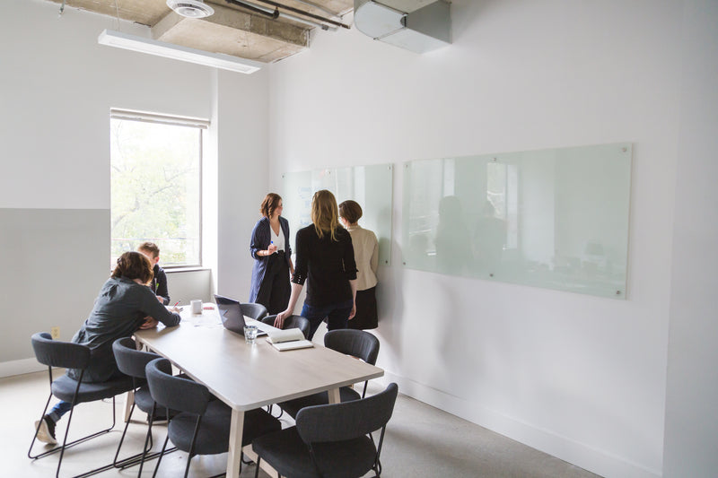 five individuals in a white room talking 